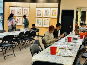 A  bright room with tables, chairs, and art supplies.