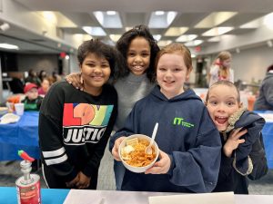 Children showing off the chili they made during a cooking program.