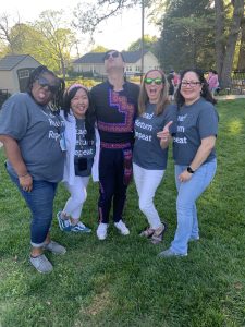 Multiethnic library staff make funny faces for a picture in the community garden at the Main Library