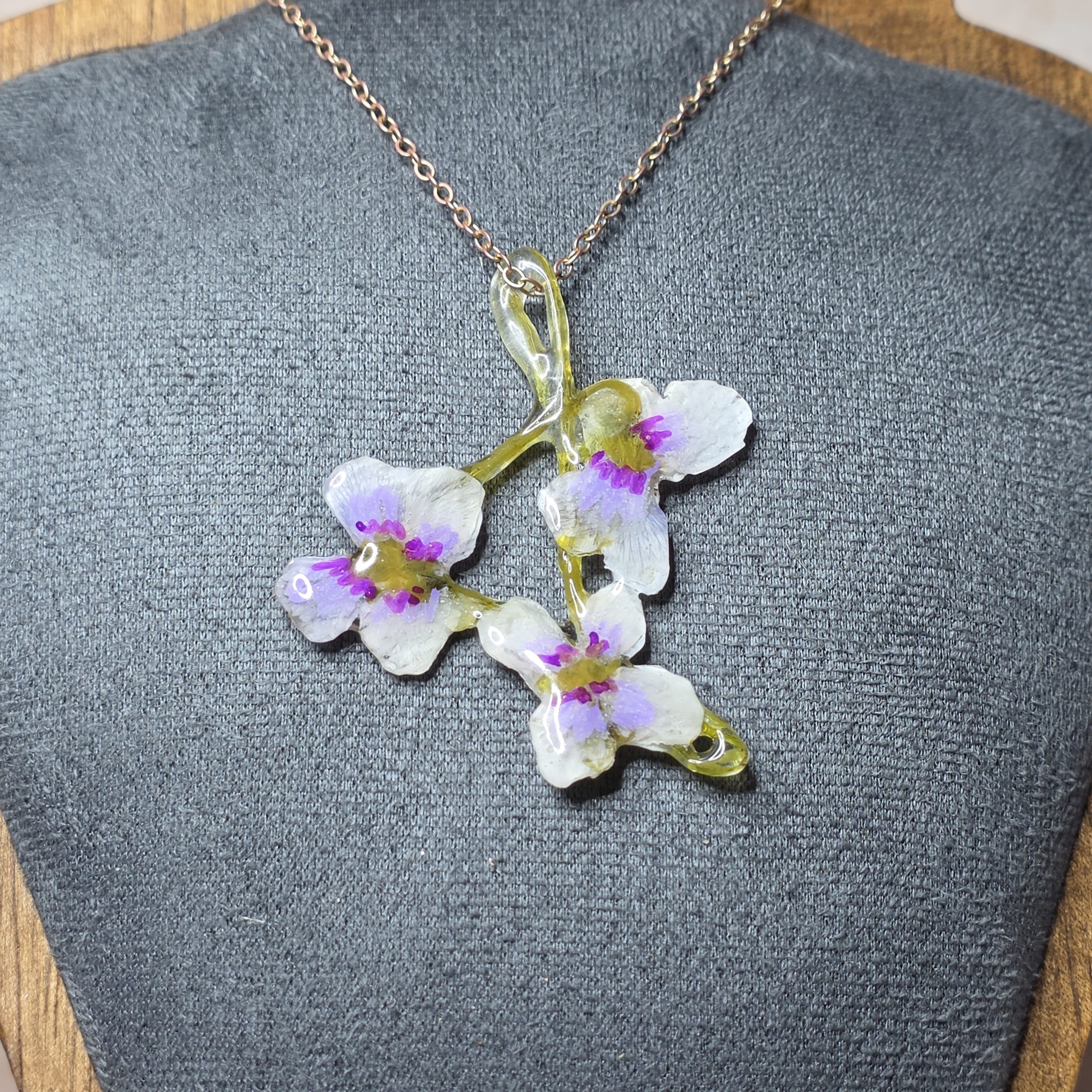 Three wild violets with their stems woven into a triangle