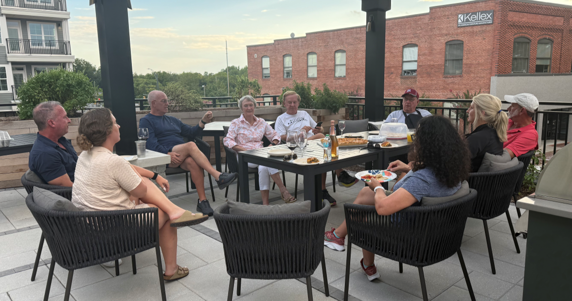 Older adults sitting around a table in front of the skyline